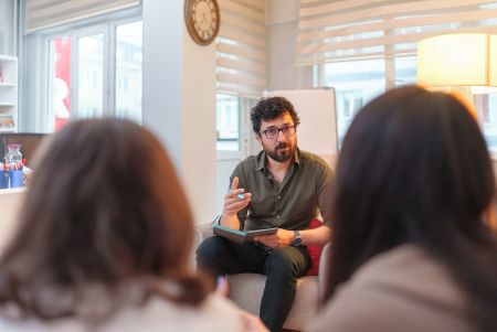 Seated man explaining things to an audience